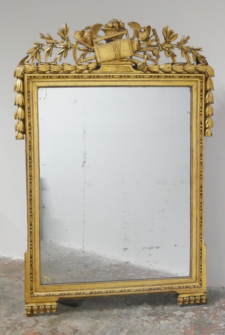 XVIIIe SIECLE Grand miroir en bois sculpté, stuqué et doré surmonté d'un trophée d'accessoires de jardinage