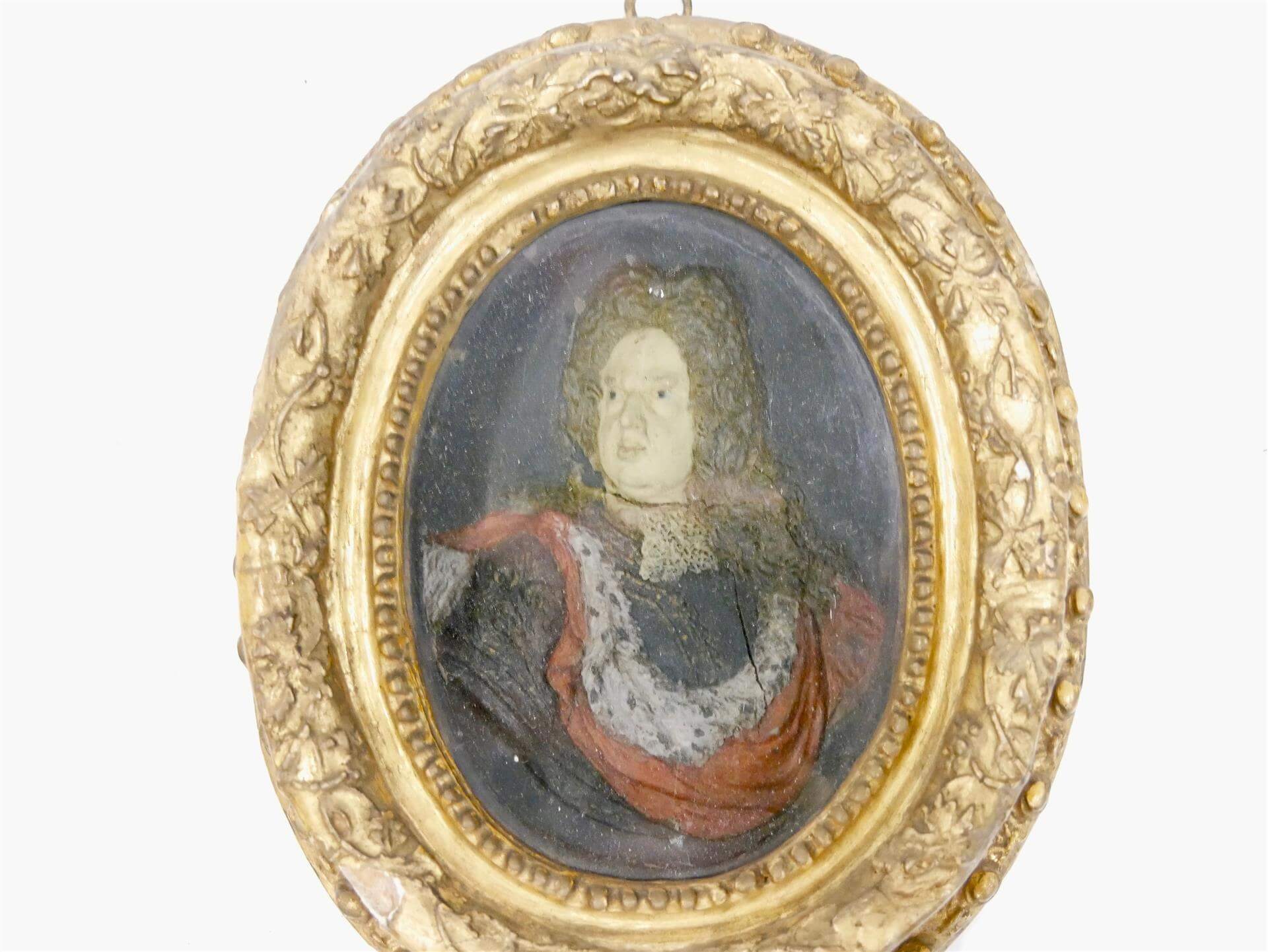 XVIIIe SIÈCLE - Portrait de Louis XIV en cire polychrome dans un cadre en bois stuqué et doré médaillon